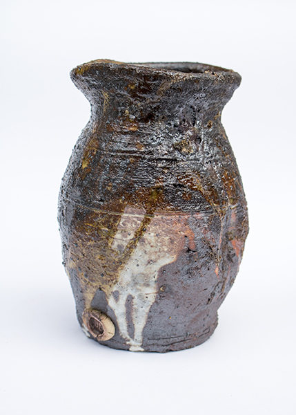 saggar fired wonky pot showing oranges, reds and whites